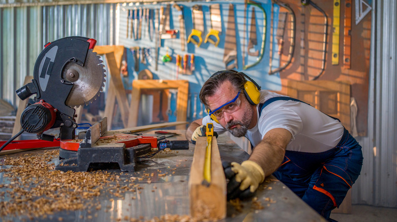 A man cutting a piece of timber.