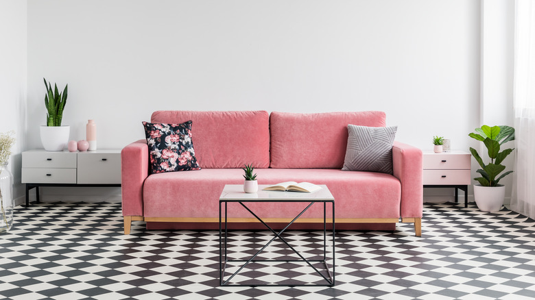 pink couch on checkerboard flooring