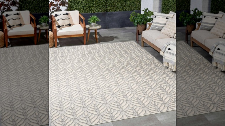 Costco's Nourison Bismarchia Indoor/Outdoor Rug surrounded by wooden patio furniture.