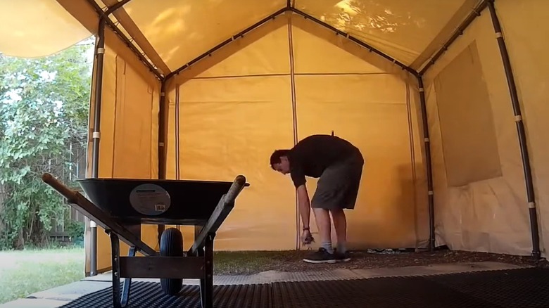Man securing the edges of a fabric carport canopy