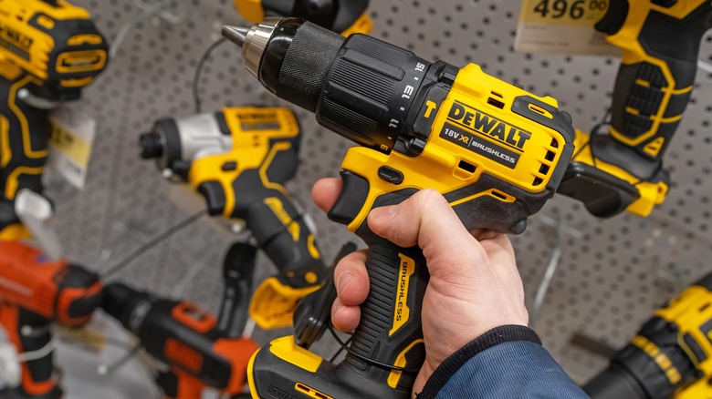 A man holding a DeWalt XR cordless power drill