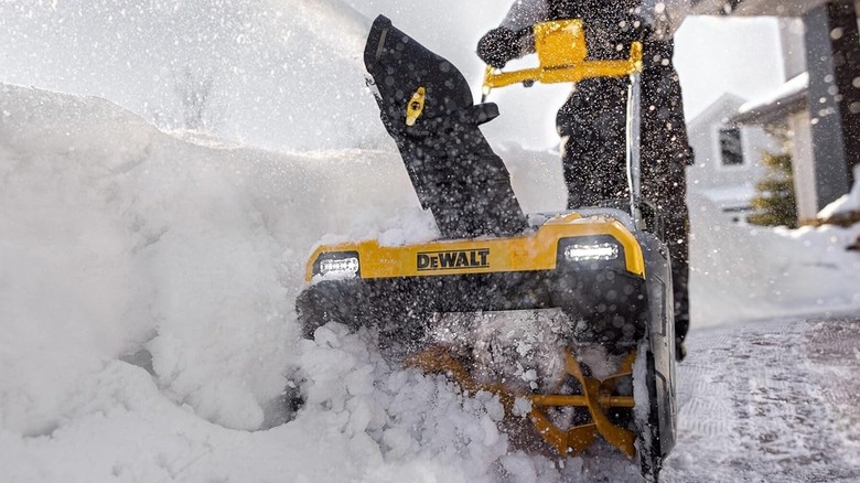 Man using a DeWalt battery-powered snow blower