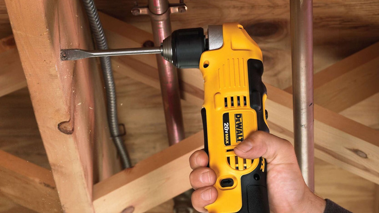 The DeWalt DCD740 right-angle drill boring a hole in a wall stud