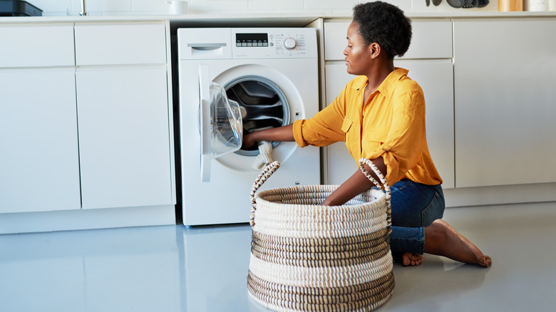 Woman adding clothes to laundry