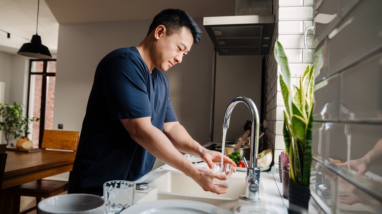 Asian man hand-washing glass cup