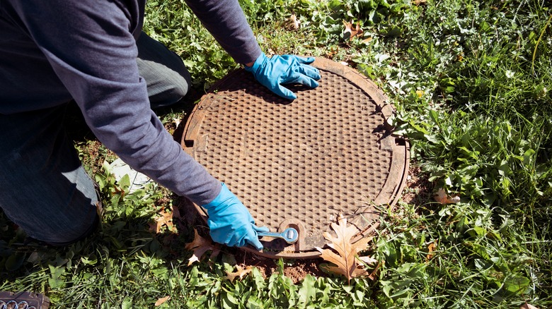 person opening septic tank