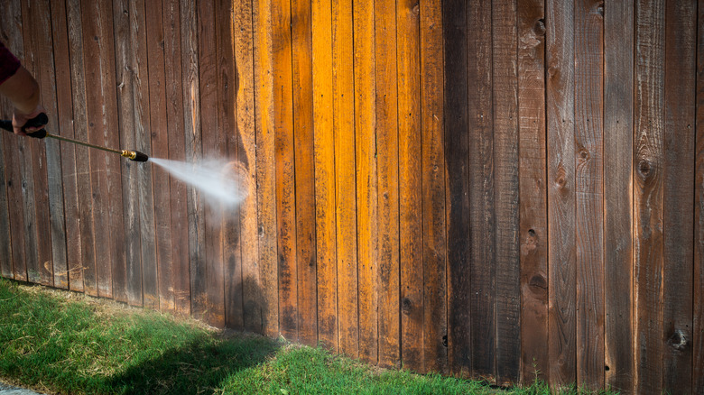 Pressure washer cleaning fence 