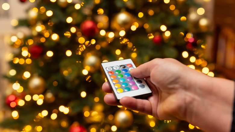 Hand holding a remote control for Christmas tree lights