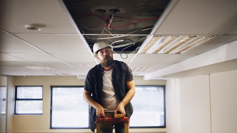 An electrician swaps out a fluorescent light fixture
