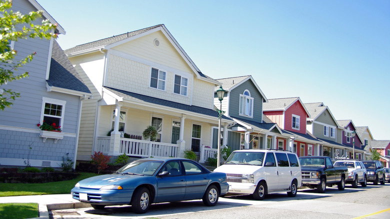 Row of cars parked on the street in front of houses