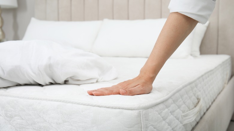 Hand on bare mattress