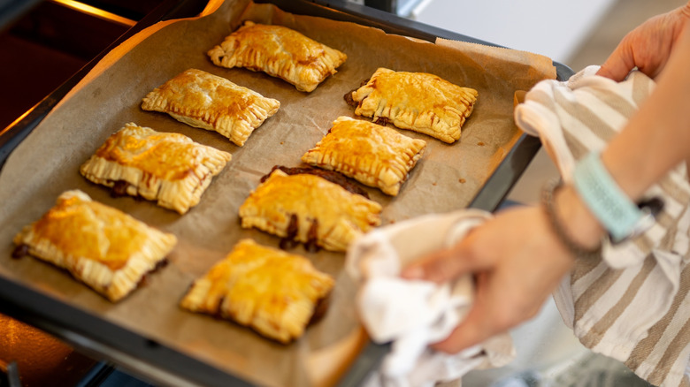 Person removing food from a hot oven