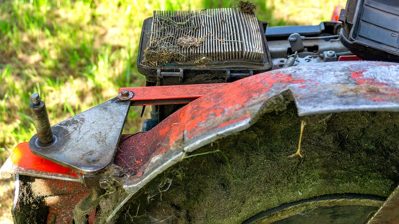 Lawn mower covered in debris