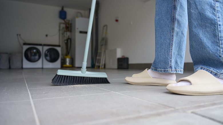 A woman sweeping the floor of the garage