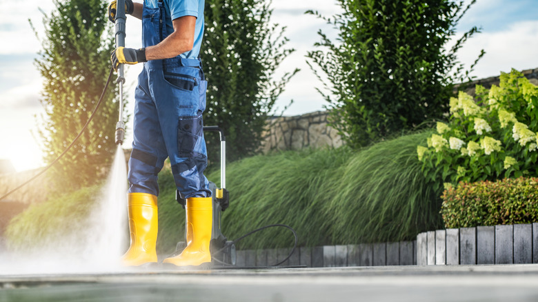 Man pressure washing driveway