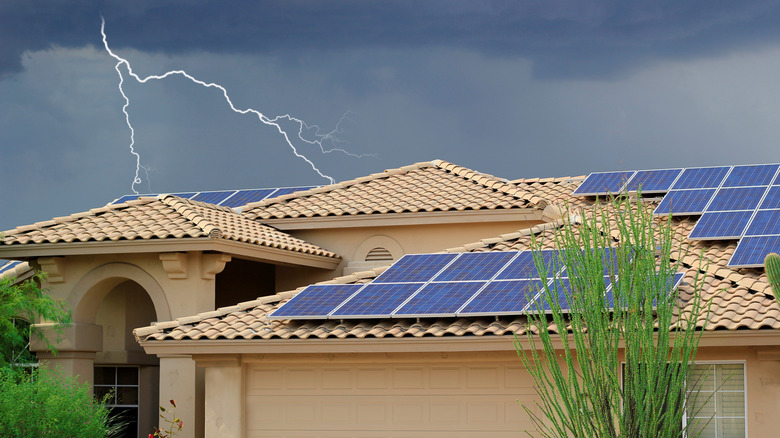 Lightning strikes residential neighborhood house on rooftop solar panels big thunder and lightning storm