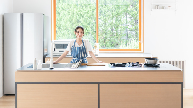 Woman at kitchen island with cooktop
