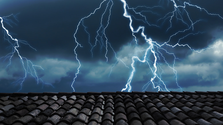 lightning in sky behind house roof