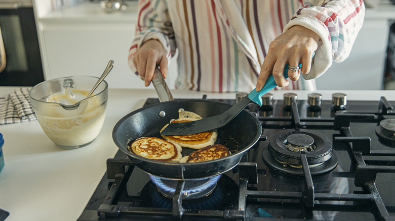 Woman cooking on a gas-powered stovetop