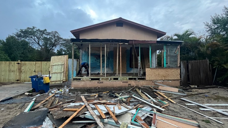 A man starts on repairing a home severely damaged by a hurricane
