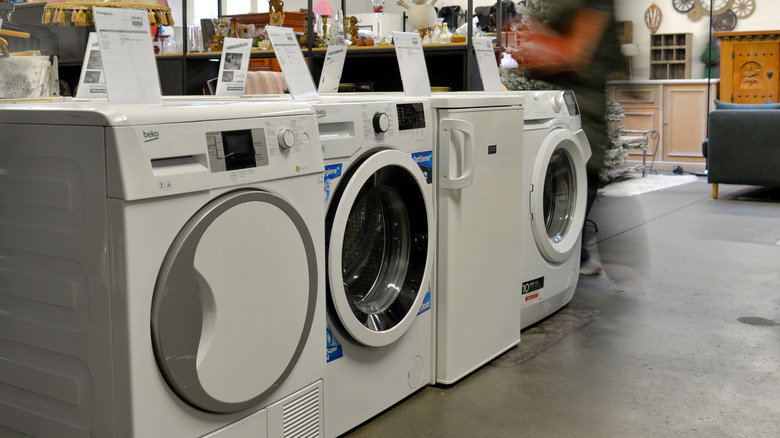 Customers of Kringwinkel, a second-hand shop, check different recycled and repurposed washing machines on November 17, 2023 in Antwerp, Belgium.