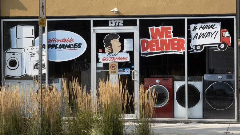 Washing machines sit in the window of an appliance store.