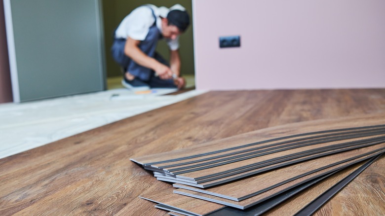 Person lays down laminate flooring