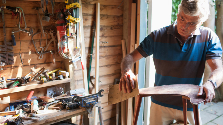 A person building a chair in a woodworking shop