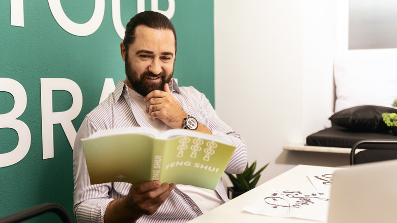 Man reading feng shui book
