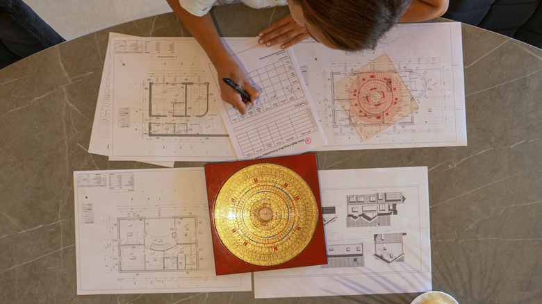 Person writing over architecture blueprints