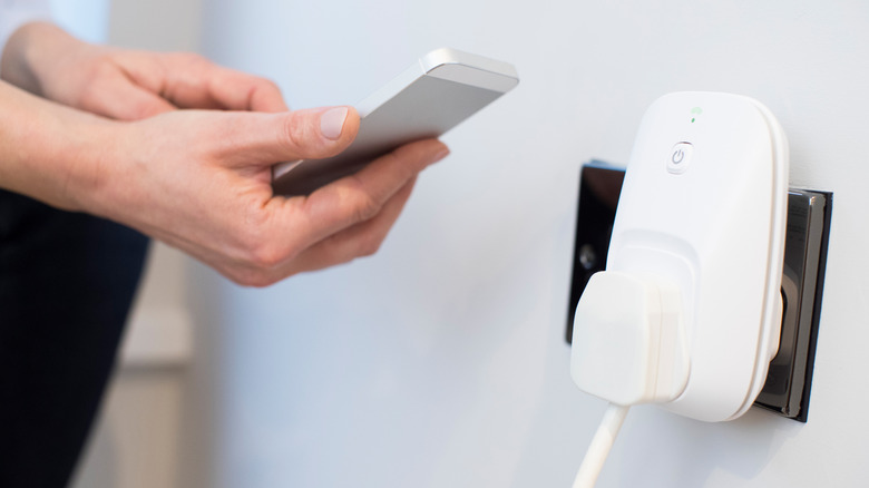 Person controlling their smart plug with a mobile app