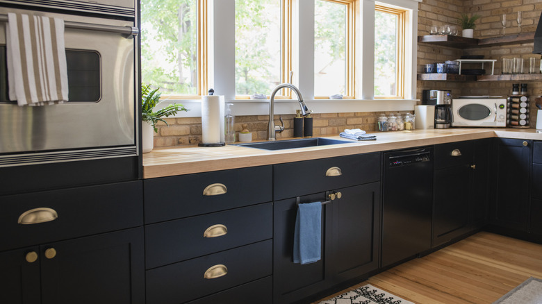 kitchen with black cabinets and wood countertop