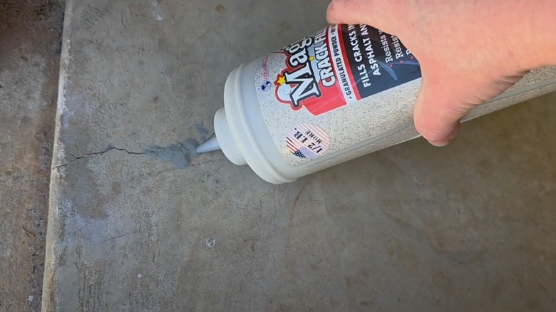 Person filling crack in concrete with Magic Crack Filler