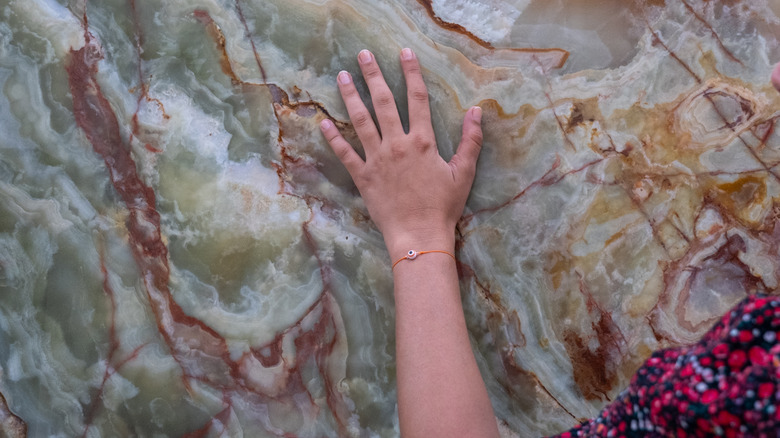 Hand touching colorful marble stone