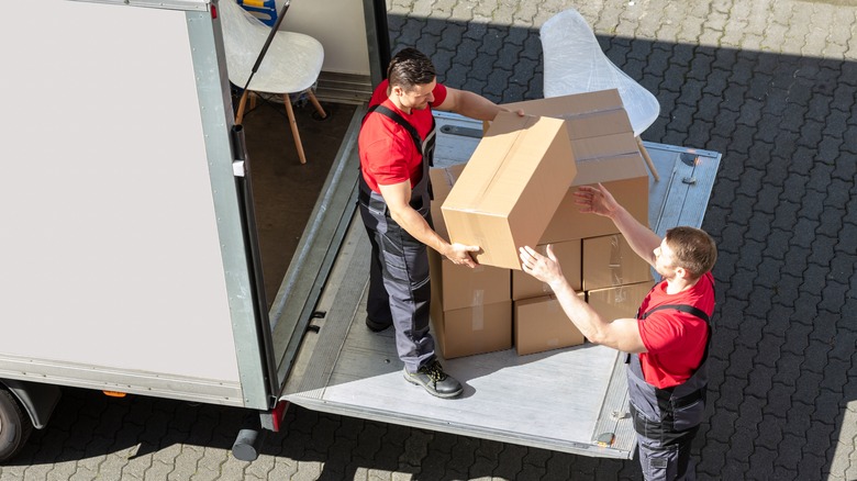 Movers load box into truck