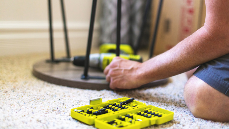 person building furniture with ryobi drill set