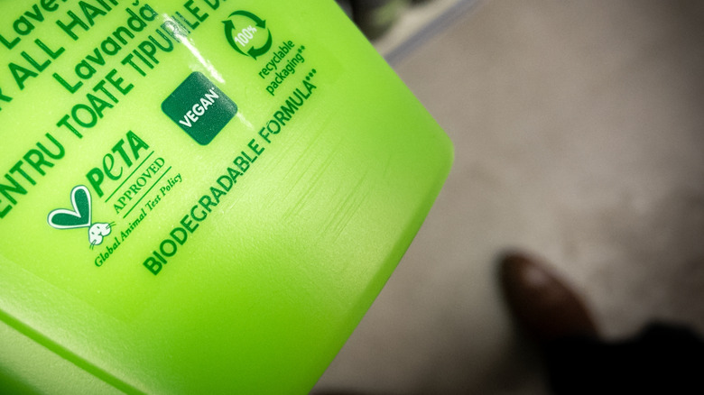 Green shampoo bottle with PETA's cruelty-free certification on it