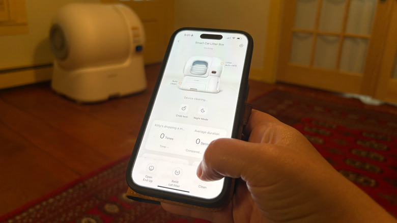 A person uses the homerunPET app to remotely clean a nearby automatic litterbox
