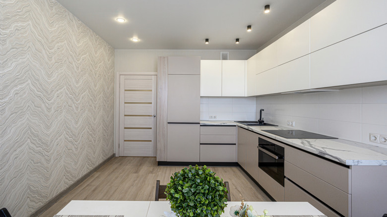 White kitchen with recessed ceiling lights.