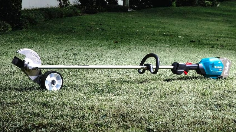 The Makita 40V max XGT Brushless Cordless Edger laying in a garden