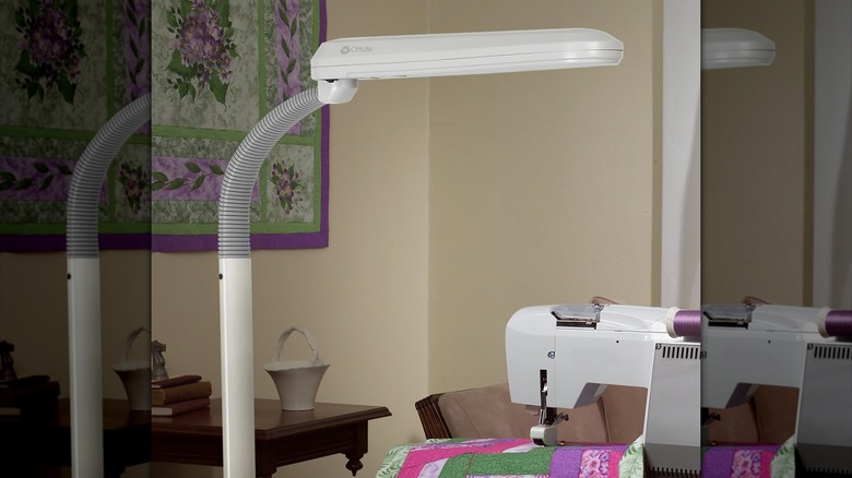 OttLite standing floor adjustable LED craft standing lamp on a sew machine with a quilt