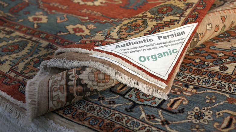 A Persian rug with a label of authenticity attached