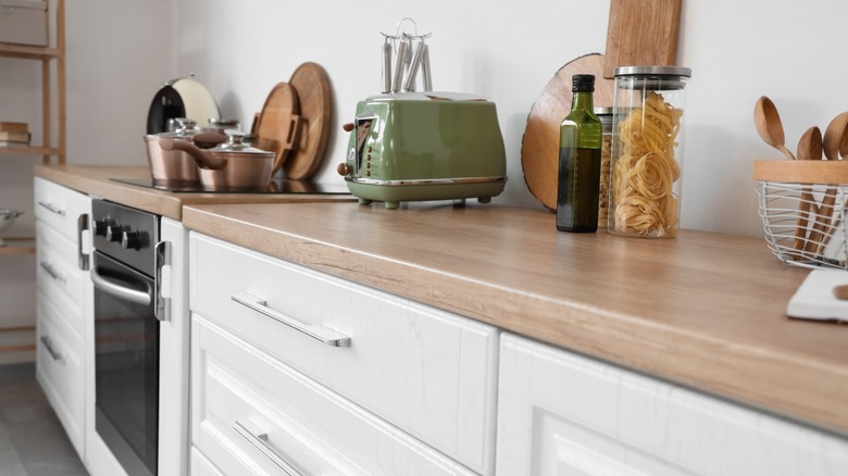 green toaster sitting on counter in light kitchen with various cooking equipment and appliances