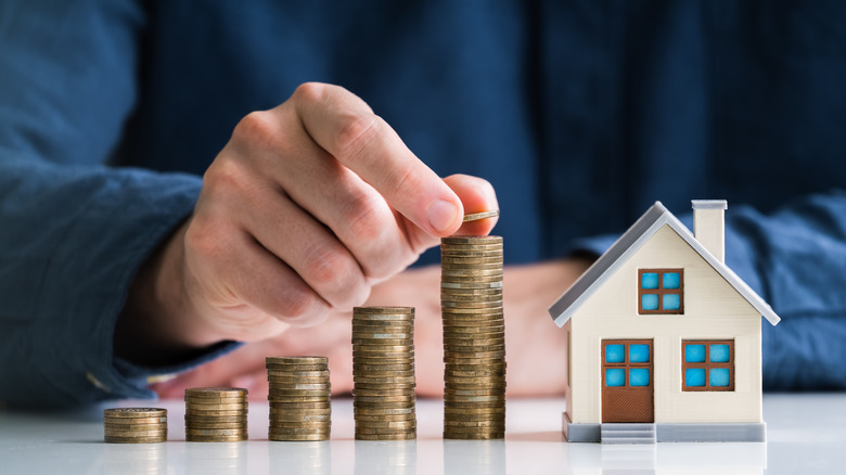 Small house next to stacked coins