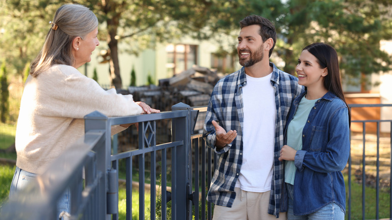 Neighbors talking over a fence