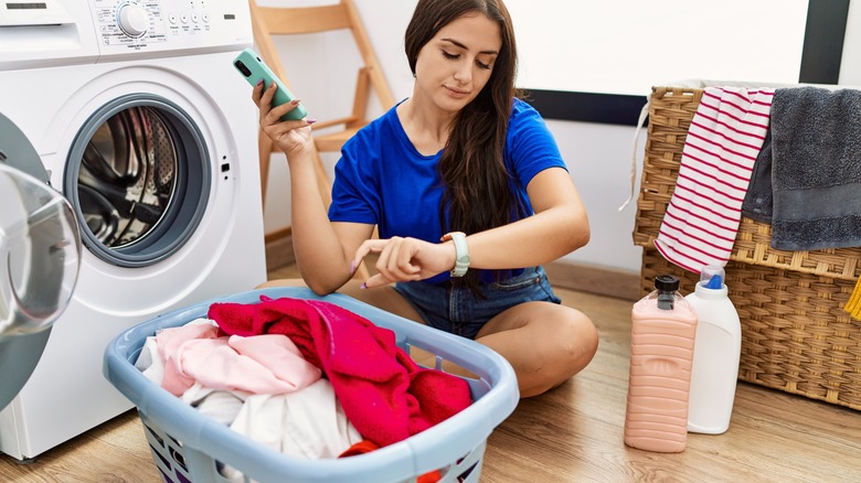 Woman checking watch by washer