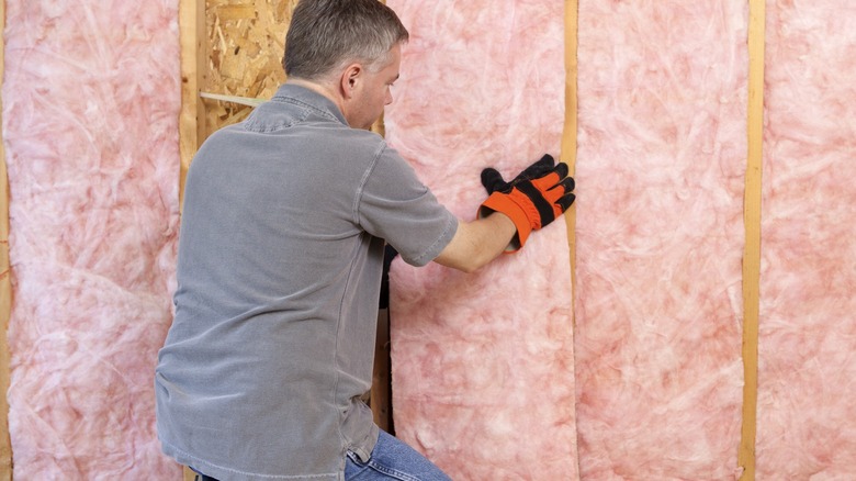 Man installing pink insulation 