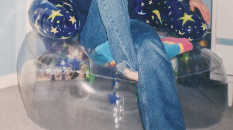 A close up of a blow up chair from 1990s with girl sitting in chair