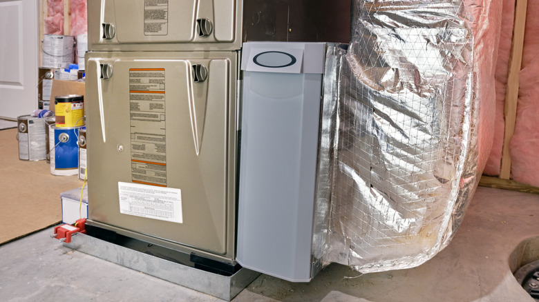 An air filtration system is attached to a modern furnace.