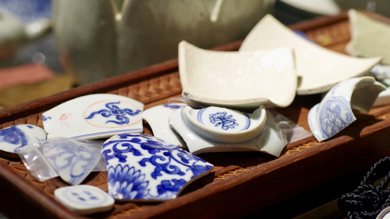 Pieces of a blue and white plate sit on a tray, ready to be reused as homemade tile.